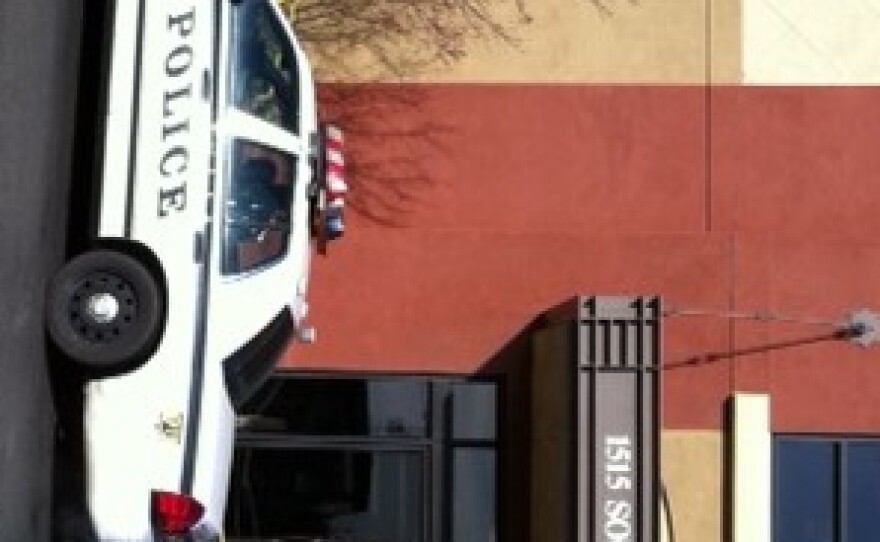 Police cars park in front of the Arvest Bank at 15th and Utica