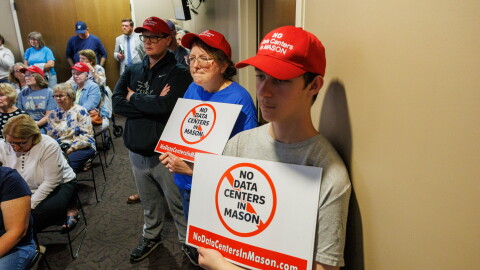 Community members opposing potential data center developments in Mason, Mich., wear custom red hats while attending a Mason City Council meeting and town hall on Sept. 14, 2026.