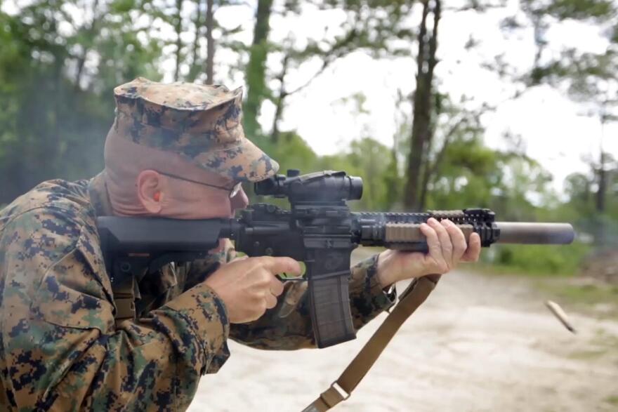 Christian Wade of the 2nd Marine Division at Camp Lejeune shoots a suppressed carbine. The surpressor is the canister on the end of the barrel.