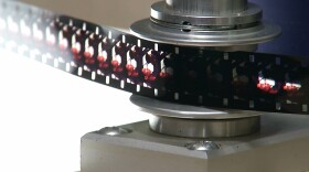 In this Dec. 15, 2015 photo, a strip of film is seen at the Moving Image Research Collections at the University of South Carolina in Columbia, S.C. The U.S. Marines Corps has partnered with the university of help preserve about 2,000 hours of silent, color films showing marines in action during World War II, Korea and Vietnam. (AP Photo/Alex Sanz)