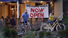 Visitors to the River Walk pass a restaurant that has reopened in San Antonio, Wednesday, May 27, 2020, as Texas reopened in the wake of the COVID-19 pandemic. (AP Photo/Eric Gay)