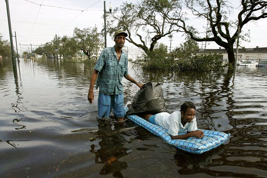 Jason Biggs pushes his wife Diane on a raft down Canal Street, flooded by Hurricane Katrina, August 30, 2005 in New Orleans, Louisiana.