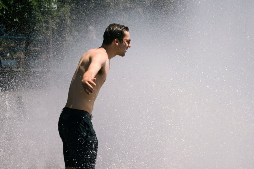 A man cools off in the Salmon Street springs fountain in Portland, Oregon as a heatwave moves over much of the United States.