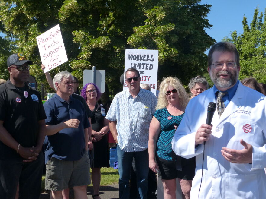 Dr. David Schwartz speaks at a rally in front of PeaceHealth RiverBend hospital. He is president of the hospitalist union.