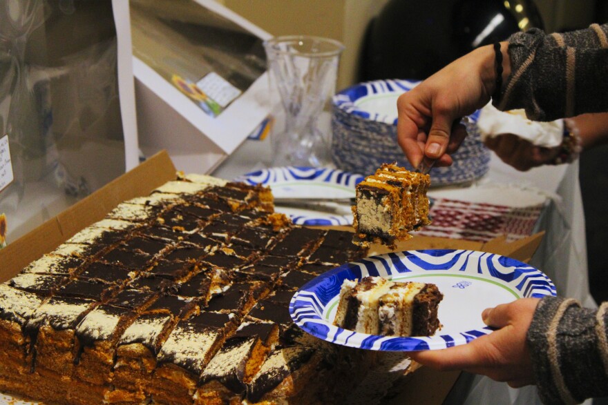 Guests at the refugee resettlement celebration have cake on Thursday, Apr. 24, 2026.