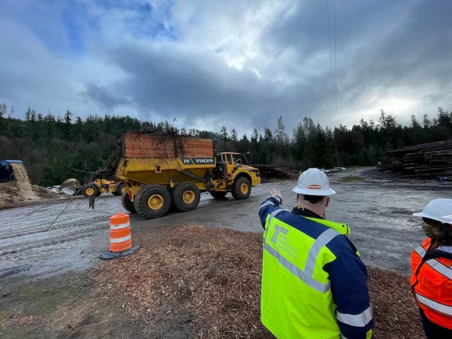 In this provided photo, Oregon Department of Transportation crews remove debris, cleaning up after the Holiday Farm Fire in 2021.