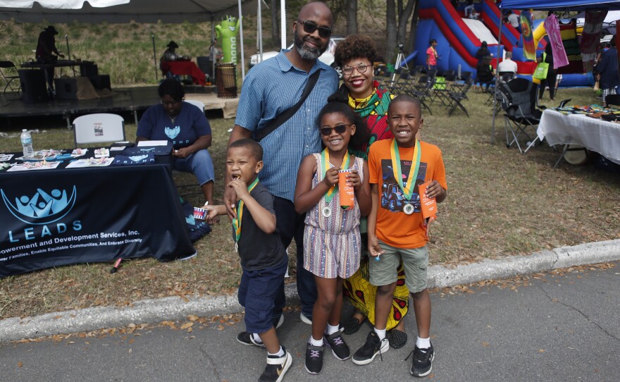 A family pose for a photo during the 2022 Publix Tampa Bay Collard Festival in St. Petersburg, Florida, on Saturday, February 19, 2022. Photo by Octavio Jones for WUSF