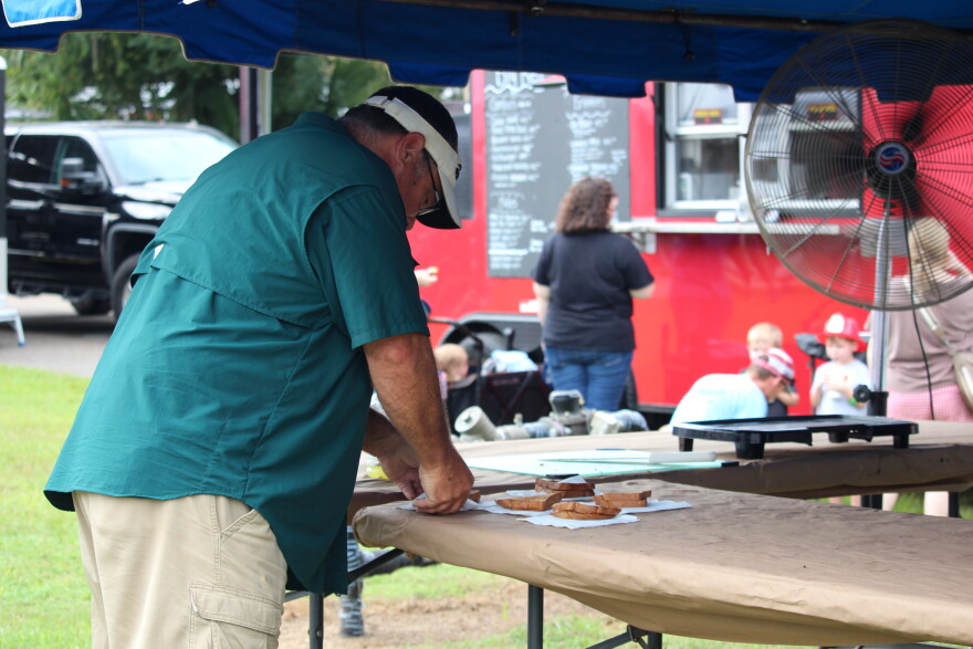 An attendee walks up to the Williston Peanuts booth to claim his free peanut butter and jelly sandwich prepared by Tyron Spearman, who is the executive director of the National Peanut Buying Points Association. (Hailey Hoffmann/WUFT News)