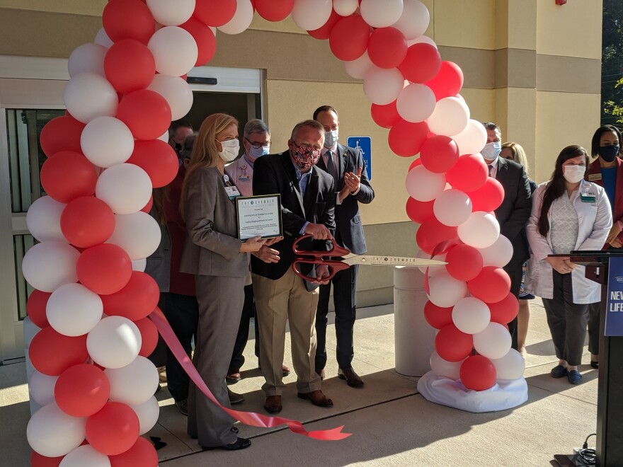 Capital Regional Medical Center administrators and the staff of the new emergency center take part in the facility's ceremonial ribbon cutting.