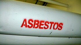 Pipes with white insulation wrap are labeled "asbestos" in red. 