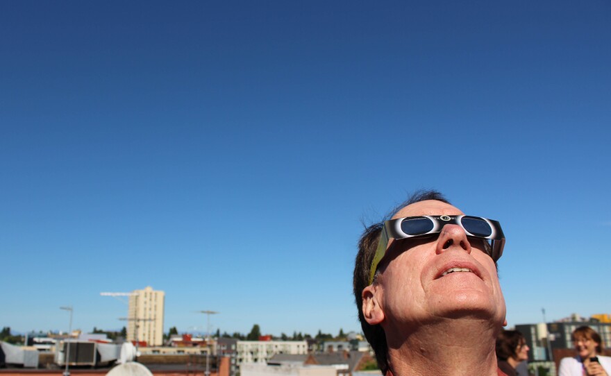 KUOW's Ross Reynolds watches the solar eclipse from the roof of the KUOW parking garage in the University District.