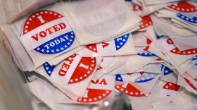 Red, white and blue "I voted today stickers," round and bordered with stars, piled up in a bin