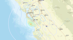 A map of an earthquake on the California Coast shows the epicenter with a large green circle and gold star and rings going outward. 