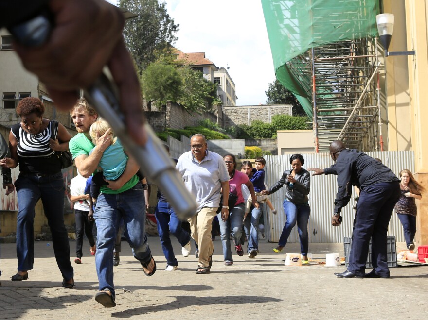 A police officer's hand, holding a gun, as security personnel pointed people to safety Saturday at the Westgate Mall in Nairobi. <a href="http://www.npr.org/blogs/thetwo-way/2013/09/23/225318992/kenyan-police-say-theyre-closing-in-on-mall-attackers">Among those in the photo</a> is a friend of Associated Press correspondent Jason Straziuso. It's the man who is clutching his daughter as they run by.