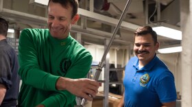 Capt. Brett Crozier, commanding officer of the USS Theodore Roosevelt, (left) washes dishes aboard the ship on Thanksgiving 2019.  Crozier was relieved of his command after urging the Navy to take stronger action to combat a COVID-19 outbreak on the ship.