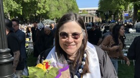 Sheryl Gann in a graduation robe with flowers
