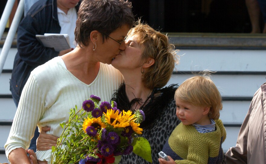 Suzanne Rotondo of New York holds daughter Phoebe while kissing Kristi Habedanck after they receive a marriage license in Provincetown, Mass., on May 17, 2004.