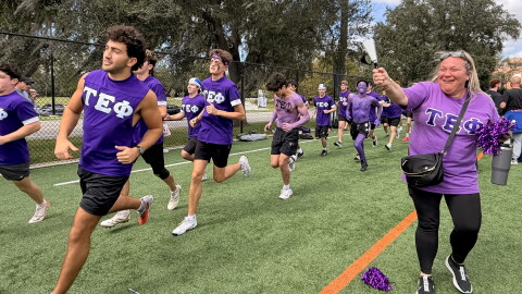 Members of Eli Silverman’s fraternity, Tau Epsilon Phi, running on the sidelines Sunday, Oct. 18, 2026. (Madison Middleton/WUFT News)