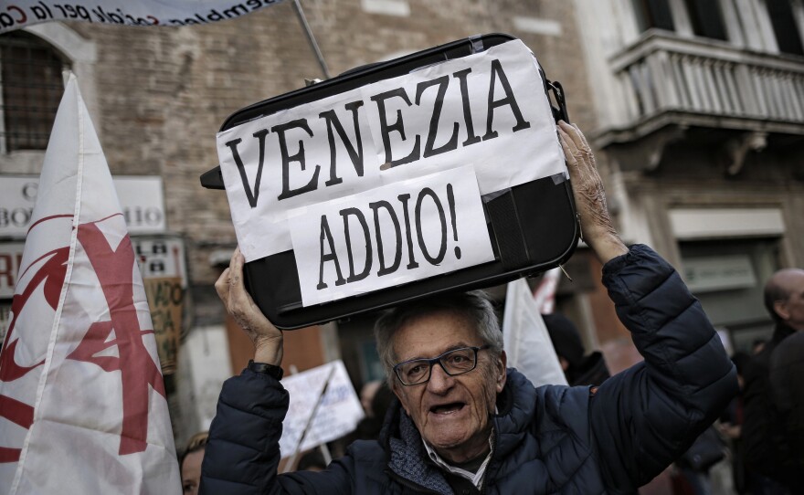 A man holds a suitcase saying "Goodbye Venice!" during a Nov. 12 demonstration against the increasing number of tourists.