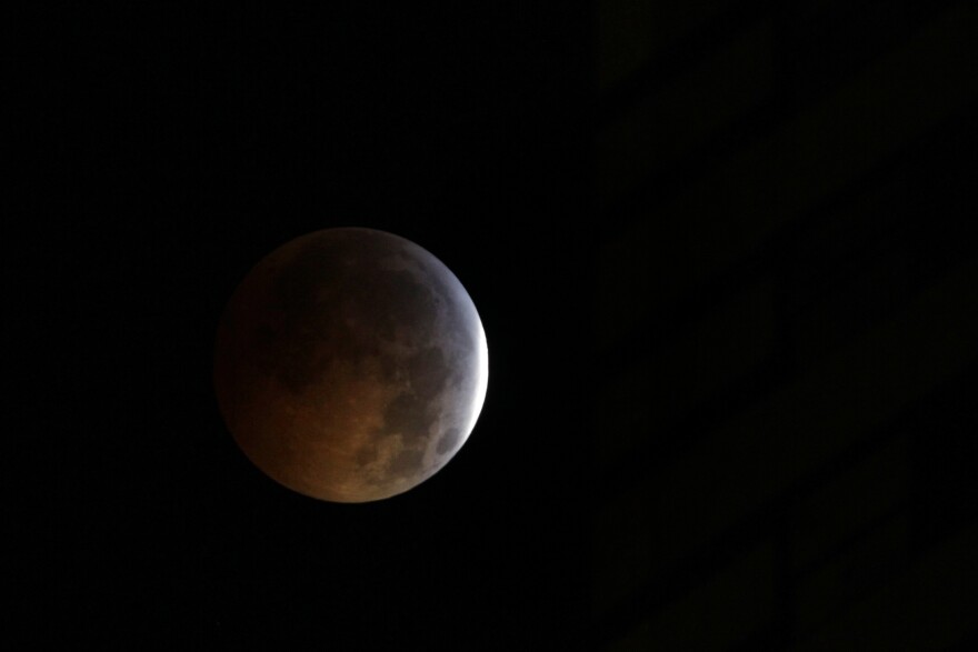 The moon is seen just before it is totally eclipsed from New York, Tuesday, Dec. 21, 2010. A total lunar eclipse occurs when the Earth casts its shadow on the full moon, blocking the sun's rays that otherwise reflect off the moon's surface. Some indirect sunlight still pierces through to give the moon its eerie hue.