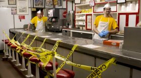 Texas Tavern employees Chris Dobe, left, and Nick Moore wait for take out orders on Monday night, March 30, 2020. Though customers are tipping well, and the diner is still open 24-7, Moore said they are making a quarter to a third less than what they normally do in tips. (Heather Rousseau/The Roanoke Times via AP)