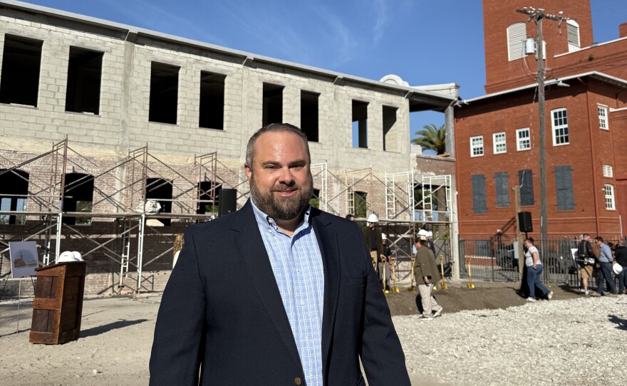 A man smiles in front of the Sanchez y Haya building 
