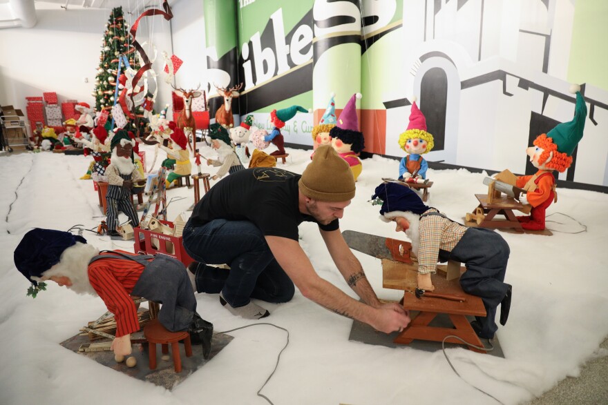 Ryan Tamer Ilgi sets up Christmas decorations that once filled the windows of Sibley's Department Store in downtown Rochester are being resurrected after years of sitting in storage for display at The Mercantile at Sibley Square during the holiday season. (photo by Max Schulte)