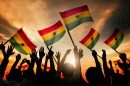 This stock images shows the silhouettes of people holding Ghanaian flags.
