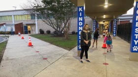 Bess Elementary students go to one of three entrances, based on their grade level. Red spots mark six-foot distances.