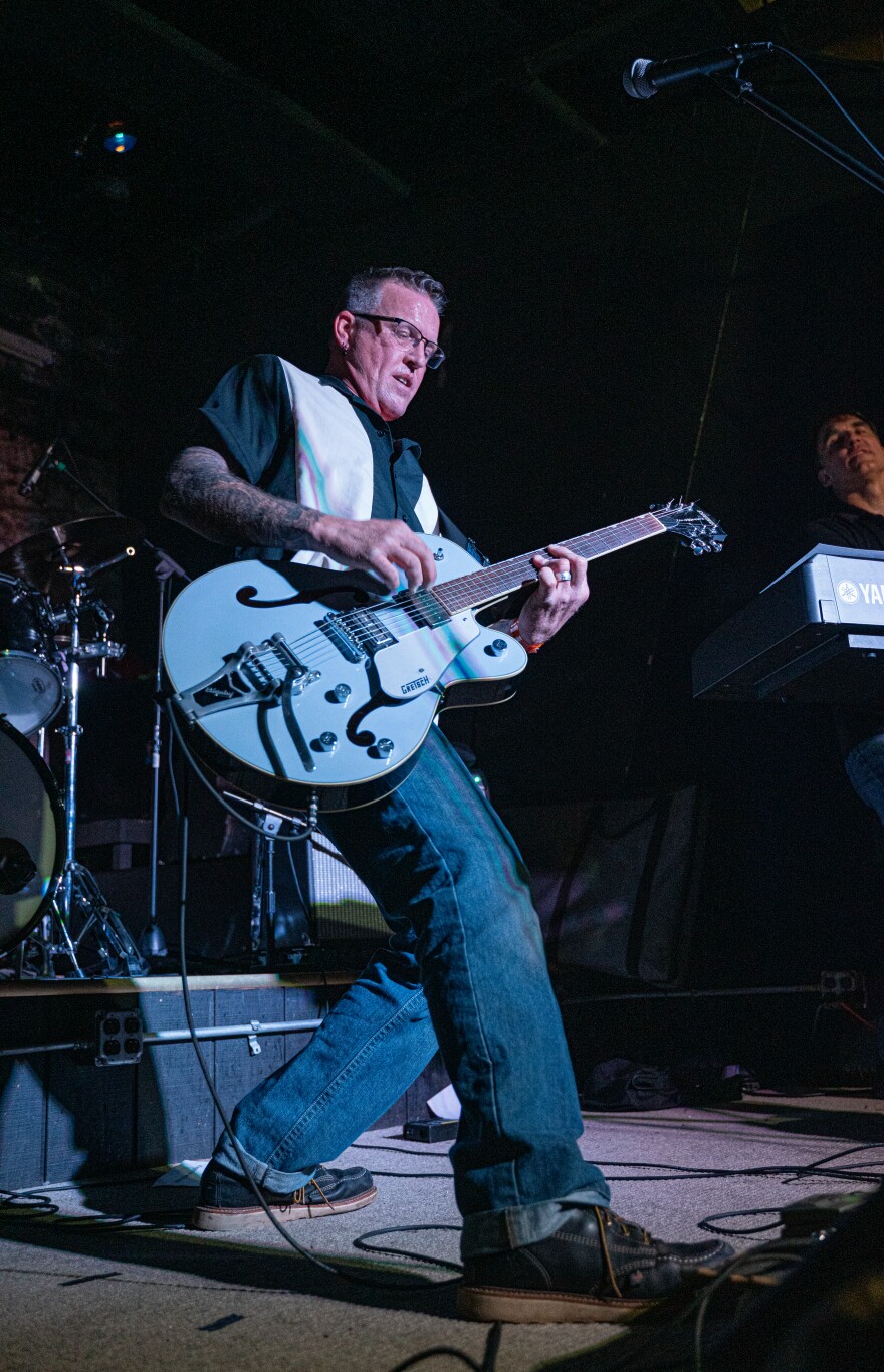 A man plays guitar on stage