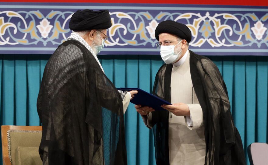 The two leaders face each other while wearing face masks.