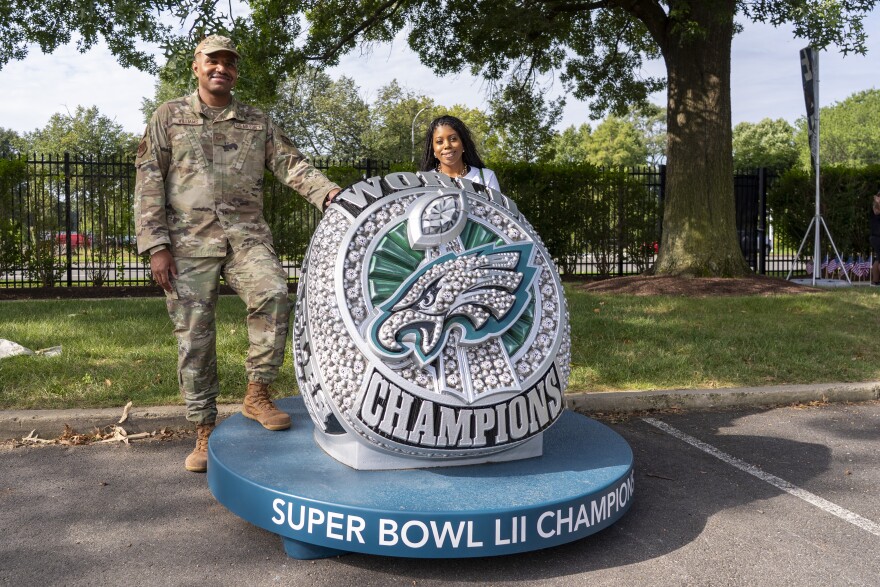 Fans pose for photos along a giant replica of the Super Bowl LII Ring during practice at NFL football training camp,Saturday, July 26, 2025. (AP Photo/Chris Szagola)