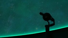 The star ball stands at the center of the planetarium in front of a display from the facility's digital projectors.