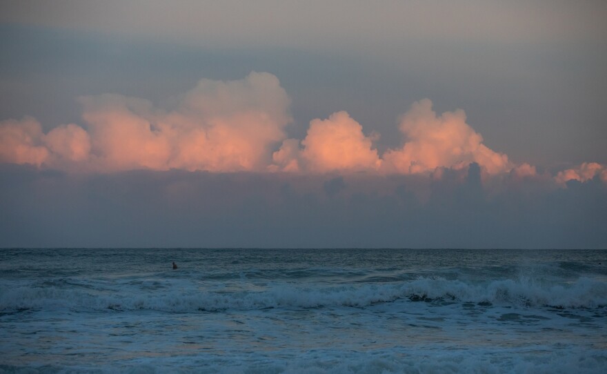 The sun sets over Wrightsville Beach as Hurricane Erin passes by off the coast on August 20 2025. The Hurricane caused larger than normal waves and brought lots of visitors and surfers to the beach.