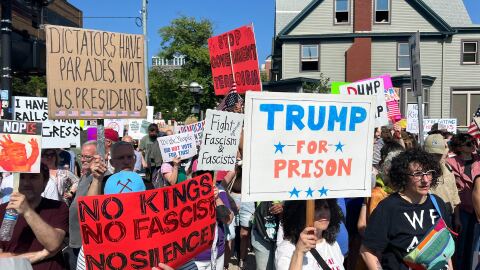 crowds of protesters gathered in downtown Ann Arbor, MI, holding signs indicating their unhappiness with President Donald Trump's administration