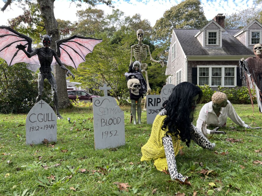 The Monac family's Halloween display at their home on Route 6A in Dennis includes a haunted graveyard, skeletons, and the Predator of the Night, left.