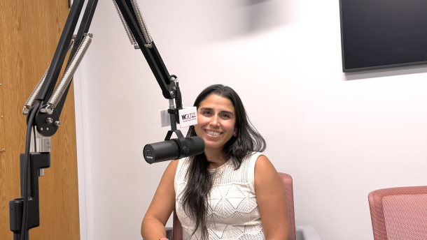 Dr. Javiera Monardez Popelka sitting behind a microphone in the WGLT studios.