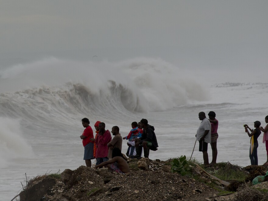 People watch waves break on the outskirts of Kingston, Jamaica, on Monday. Hurricane Matthew has generated large surf, heavy rain and wind.