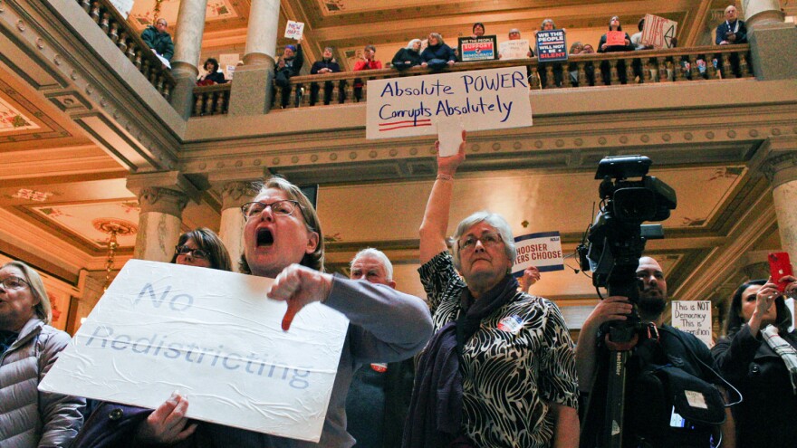 Protestors hold signs and shout against the push to redistrict in Indiana at the statehouse on Monday, Dec. 1, 2025 after the Indiana House released its new proposed map.