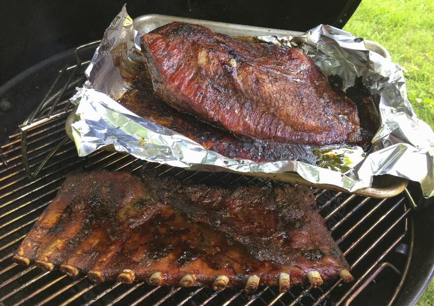 Kathy's Texas-style brisket (top) and dry-rubbed pork ribs on the grill. (Kathy Gunst for Here & Now)