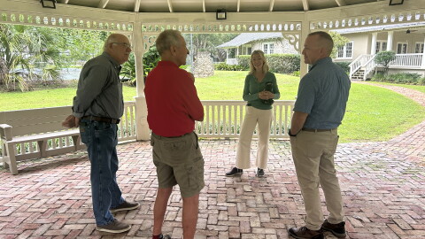 Barbara Hooper, who helped organize the festival, discusses Saturday's logistics with three members of Pasture Prime Bluegrass: Mike Matz (left), Will Harding (middle) and Brian Young (right).