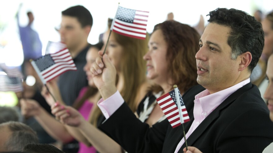 New citizens wave American flags during a U.S. Citizenship and Immigration Services naturalization ceremony in Miami in July.