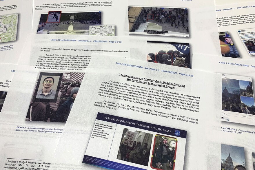 FILE - The Statement of Facts supporting the arrest warrant for Matthew Jason Beddingfield on charges stemming from last year's riot at the U.S. Capitol, is photographed on Feb. 8, 2022. A North Carolina man who stormed the U.S. Capitol while free on bail for an attempted murder case pleaded guilty Thursday, Feb. 16, to attacking police officers with a pole attached to an American flag during the mob's riot. Beddingfield appeared to flash a Nazi salute toward the Capitol after attacking officers trying to protect the building from rioters on Jan. 6, 2021, according to federal prosecutors. (AP Photo/Jon Elswick, File)