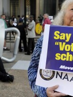 Gloria Gilman holds a sign Thursday in Philadelphia during the NAACP voter ID rally to demonstrate her opposition to Pennsylvania's new voter identification law.