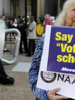 Gloria Gilman holds a sign Thursday in Philadelphia  during the NAACP voter ID rally to demonstrate her opposition to Pennsylvania's new voter identification law.