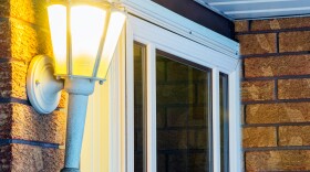 Elegant ornate porch light glowing by front door, welcoming inviting scene