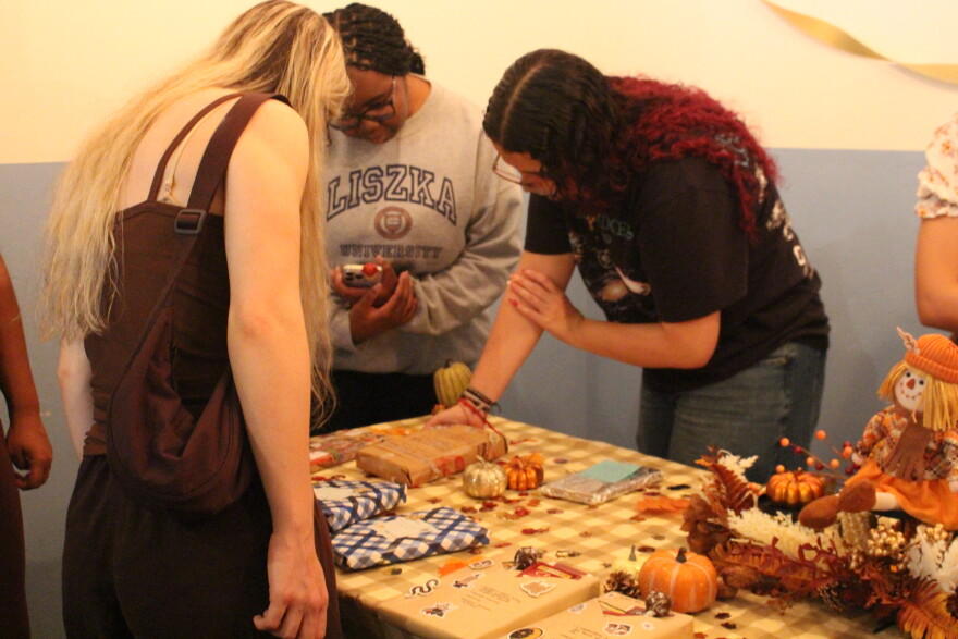 Kayla McCray, center, and other guests choose a book to read during a blind book swap at Coterie Market on Saturday, Sept. 19. The activity was one of several hosted by the business on West University Avenue over the weekend. (Hailey Hoffmann/WUFT)