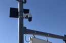 Surveillance cameras mounted to  a lightpole. 