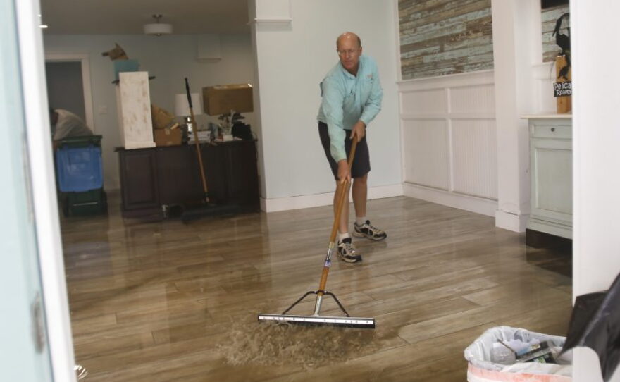 Shawn Stephenson clears water from a real estate office that was flooded by Hurricane Hermine Friday, Sept. 2, 2016, in Cedar Key, Fla. Hermine was downgraded to a tropical storm after it made landfall. (AP Photo/John Raoux)