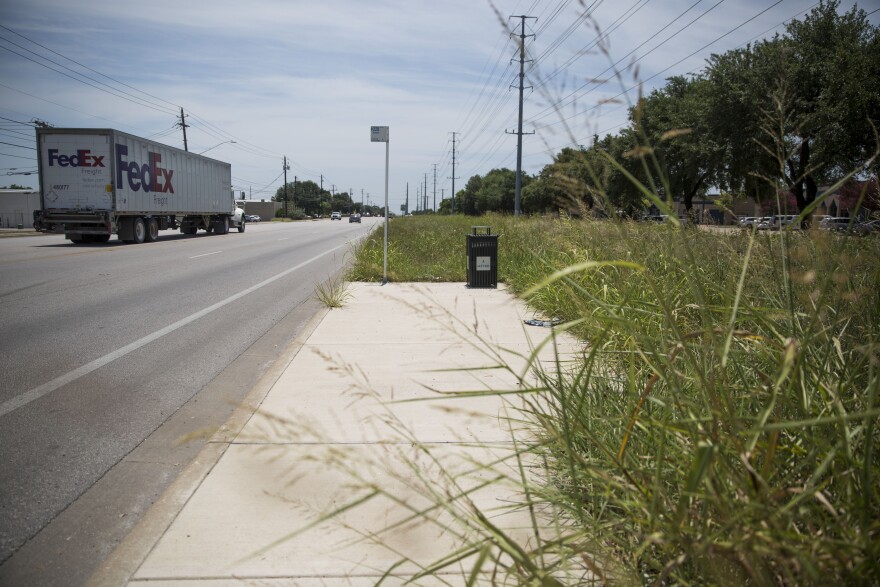 A bus stop on Burleson Road without a bench, shelter or lighting.